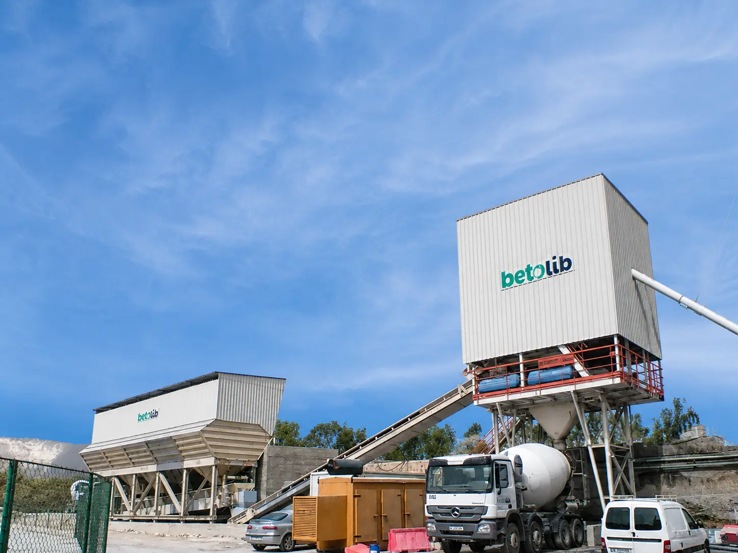 Concrete batching plant with aggregate bins and mixer loading system
